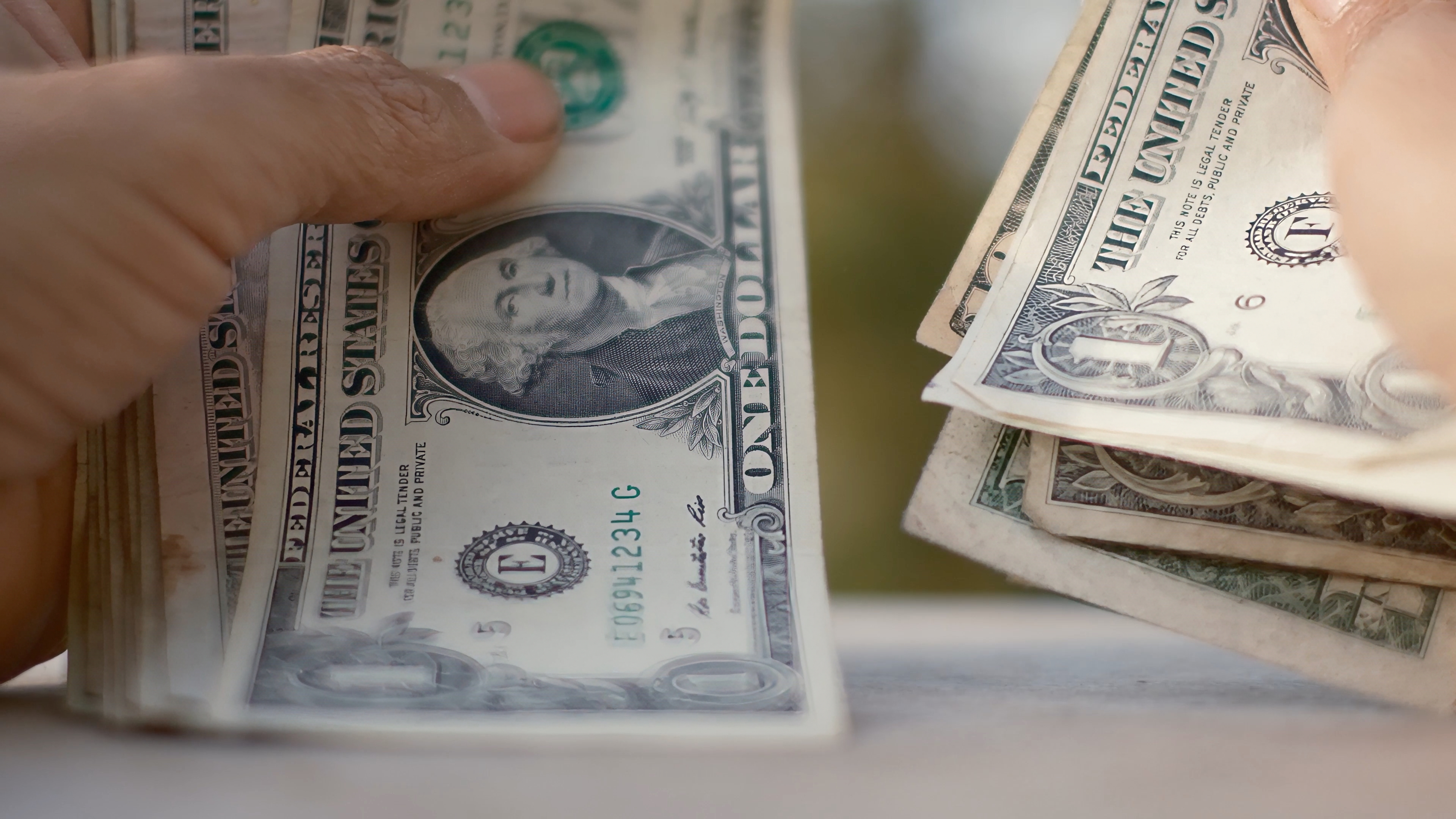 Person's hands counting an american one dollar bills stack, handling currency for concepts of finance, budget, or debt, showing economic transaction and wealth management